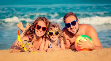 Happy family playing at the beach. Summer vacation concept