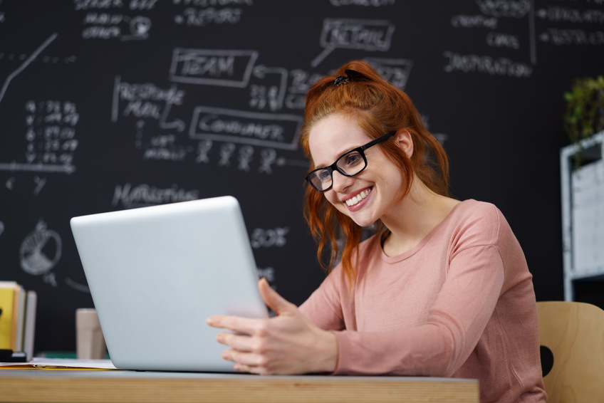 lächelnde junge frau arbeitet am computer