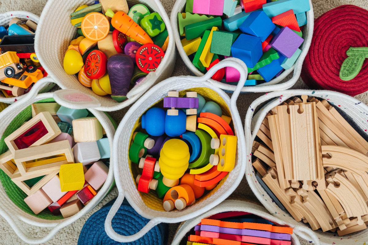 Colorful Toy Storage Baskets in the children's room. Cloth stylish Baskets with wooden toys. Organizing and Storage Ideas in nursery. Clean up toys and reduce the clutter. Top view