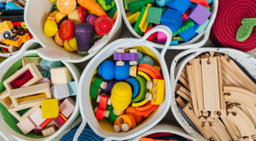 Colorful Toy Storage Baskets in the children's room. Cloth stylish Baskets with wooden toys. Organizing and Storage Ideas in nursery. Clean up toys and reduce the clutter. Top view