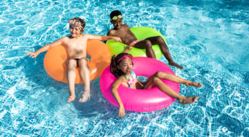 kids smiling and happy in the pool on a sunny summer day